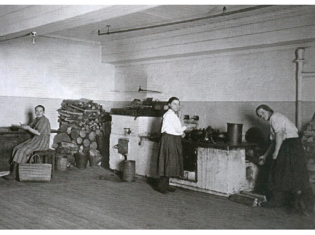 Кухня в коммунальной квартире, Ленинград, 1920-е. Вместо плит — печи на дровах. Водопровода нет, воду приносят в ведрах.